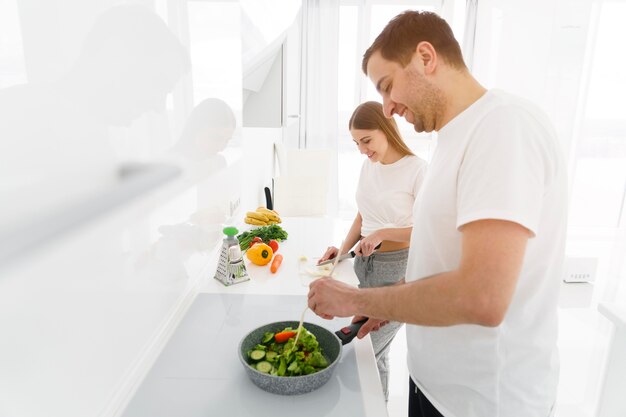 Side view couple making salad