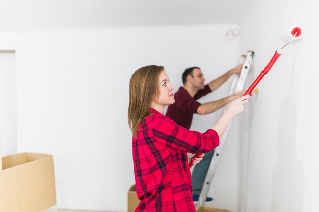 Side view couple painting wall