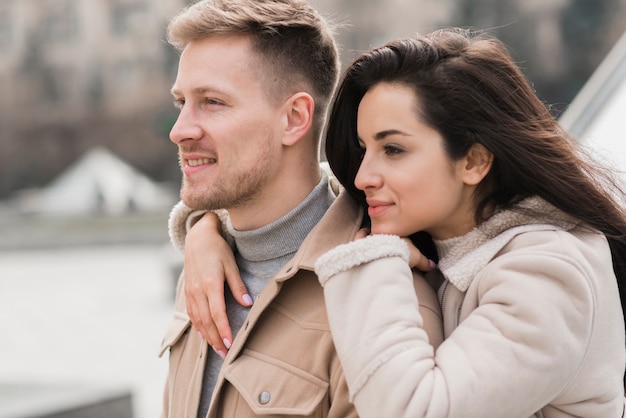 Side view of couple posing outside