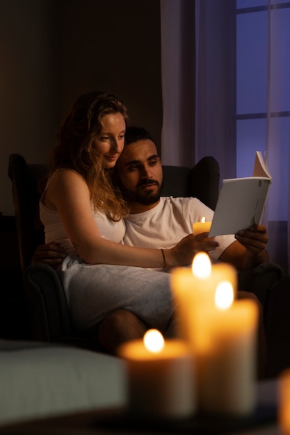 Free photo side view couple reading together at home