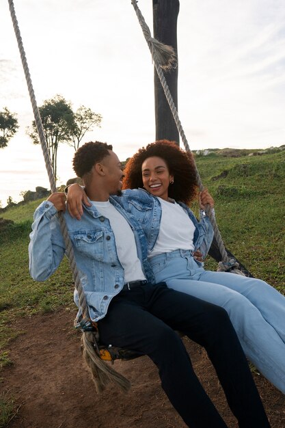 Side view couple on swing outdoors