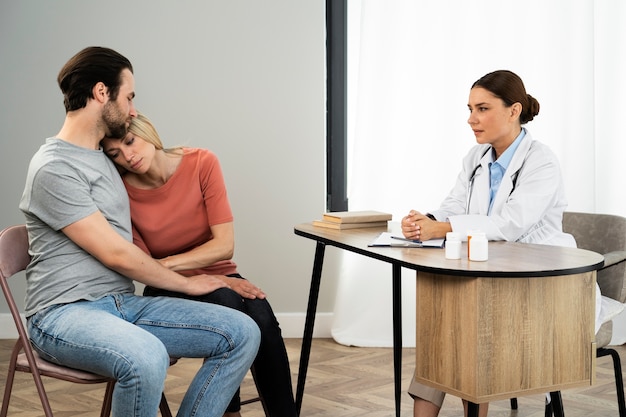 Side view couple talking to doctor