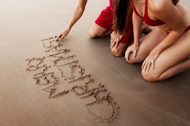 Пара, вид сбоку, пишет на песке