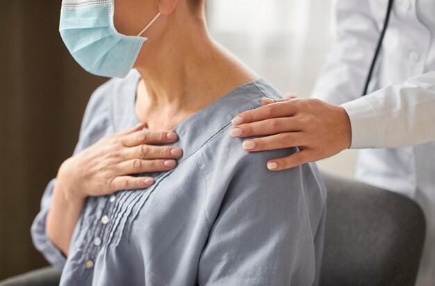 Side view of covid recovery center female doctor checking elder patient