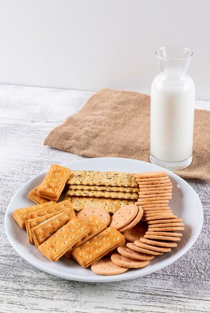 Side view crackers with milk on white wooden table