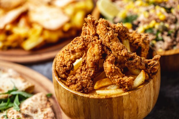 Side view crispy fried chicken tenders with french fries