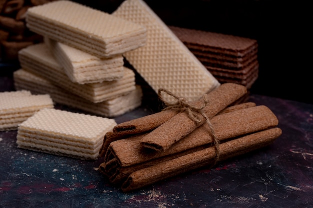 Side view of crispy sticks tied with rope and waffles on dark