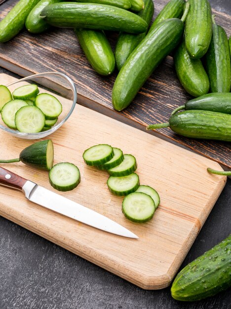 Side view cucumber sliced on wooden cutting board