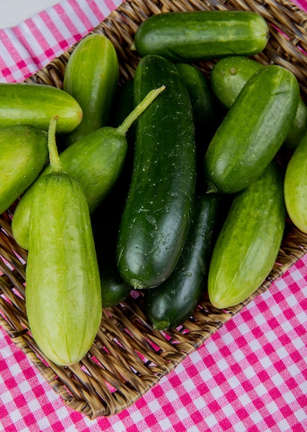 Side view of cucumbers in basket plate on plaid cloth