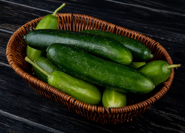 Side view of cucumbers in basket on wooden surface