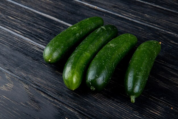 Free photo side view of cucumbers on wooden surface