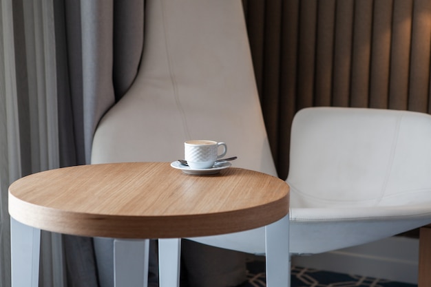 Side view cup of coffee on a small round table horizontal