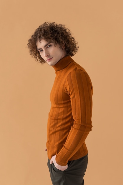 Side view curly haired man with brown blouse posing