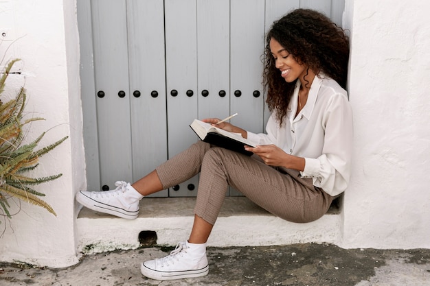 Side view curly woman reading a book