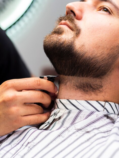 Side view of customer getting his beard cut