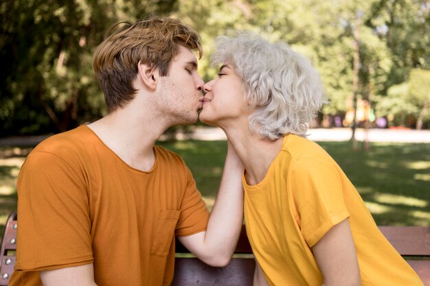 공원에서 키스를 공유하는 귀여운 커플의 모습
