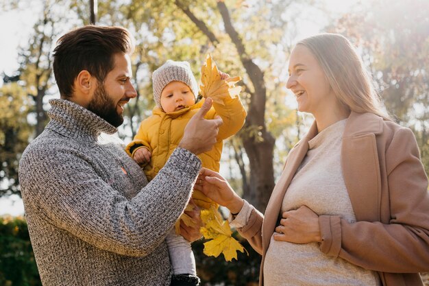 Side view of dad and mother with baby outdoors