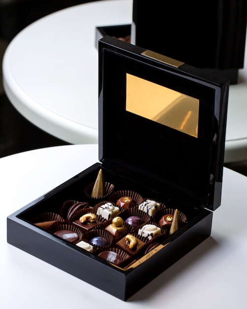 Side view decorated chocolate candy in a black gold box