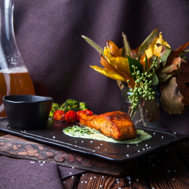 Side view delicious meal in black tray on dark wooden background with decorations