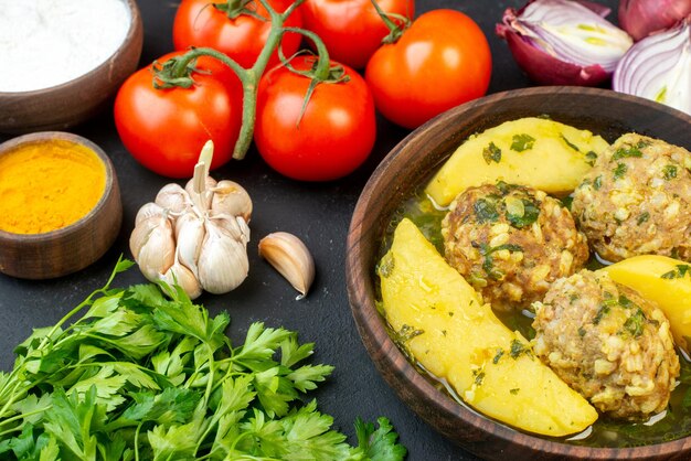 Side view of delicious meatball meal fresh vegetables yellow ginger flour on black background