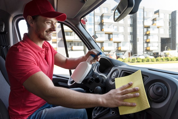 Free photo side view delivery man cleaning car