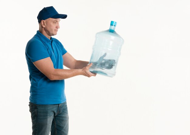 Side view of delivery man holding water bottle