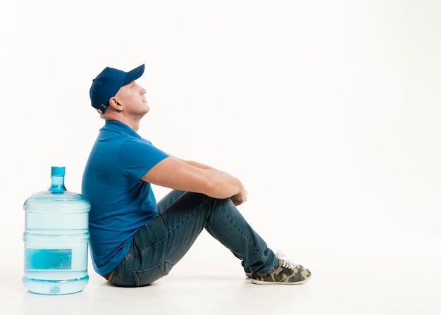 Side view of delivery man with cap and copy space