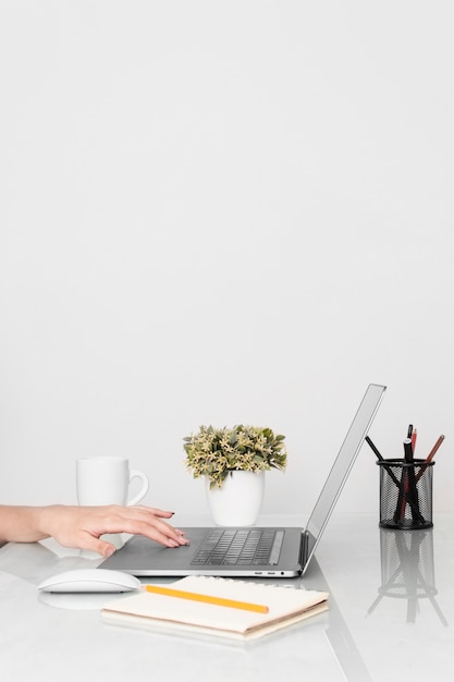 Side view of desk top with hands and laptop