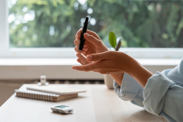 Foto gratuita donna diabetica con vista laterale che controlla il livello di glucosio