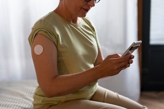 Бесплатное фото Женщина-диабетик, вид сбоку, проверяет уровень глюкозы
