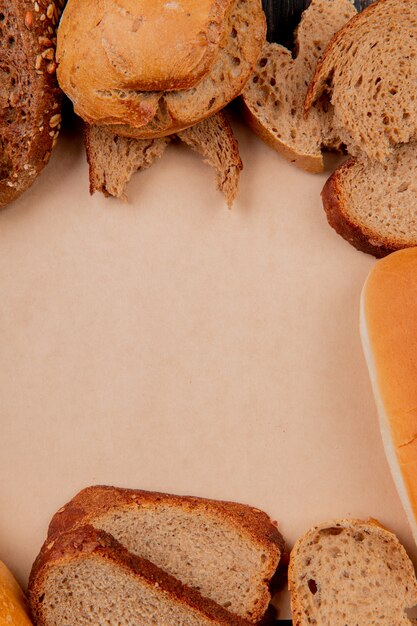 Side view of different breads as rye black baguette sandwich ones on cardboard surface with copy space