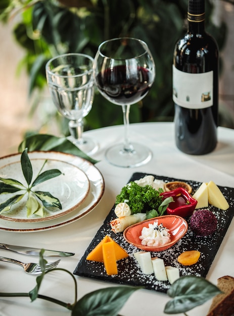 Side view of different types of cheese on white plate on table