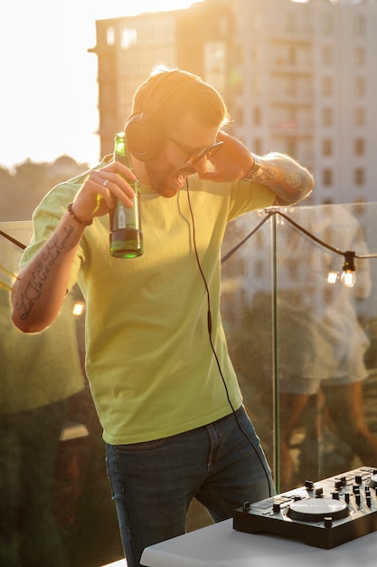 Free photo side view dj holding beer bottle