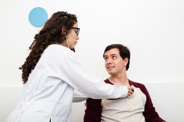 Side view doctor checking a patient