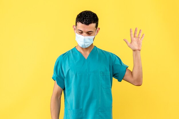 Вид сбоку врач Врач в маске говорит о важности мытья рук