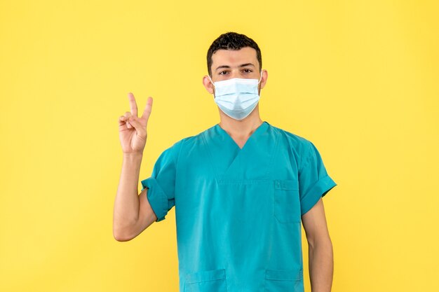 Вид сбоку: врач в маске рассказывает о симптомах коронавируса