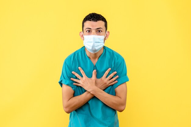 의사의 측면보기 마스크를 쓴 의사가 숨가쁨이 코로나 바이러스의 증상이라고 말한다