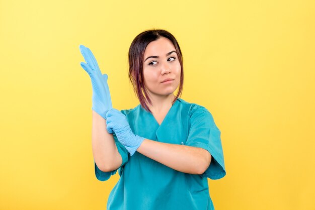 Side view of a doctor encourages people to wear gloves during a pandemic