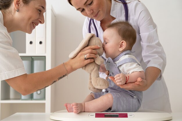 Side view doctor holding cute baby