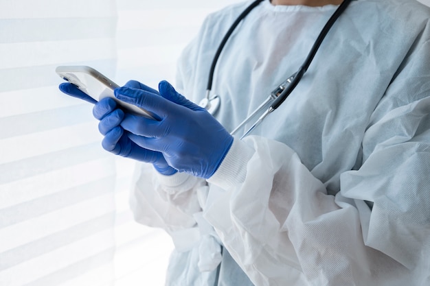 Side view doctor holding smartphone