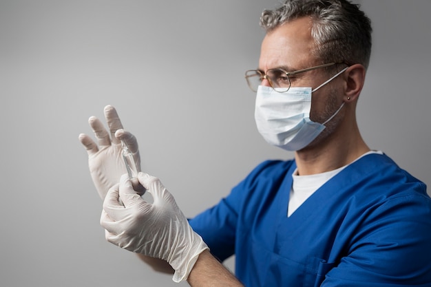 Free photo side view doctor holding vaccine vial