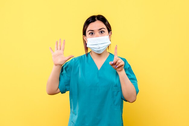 Side view of a doctor in mask encourages people to hand washing