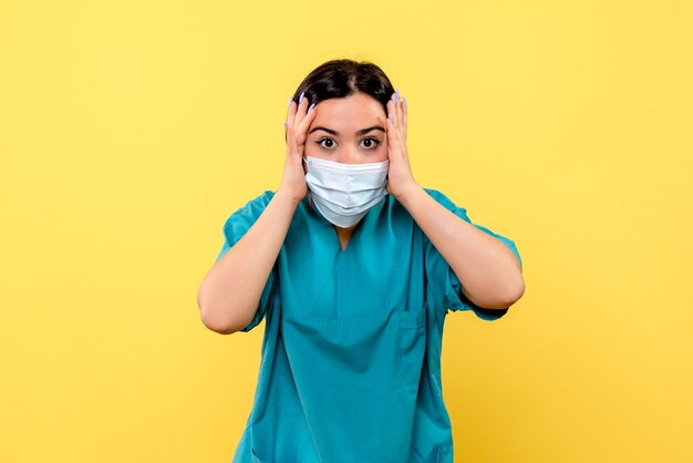 Side view of a doctor in mask talks about the importance of wearing mask