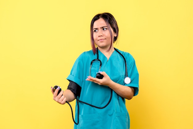 Side view of the doctor in medical uniform measures the pressure