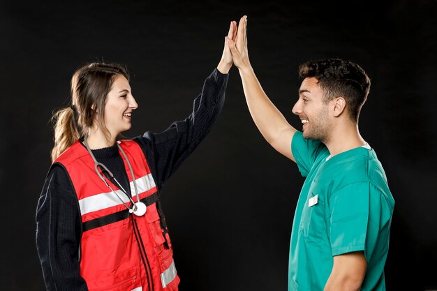 Side view of doctor and paramedic high-fiving each other