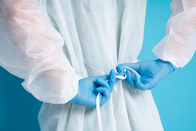 Free photo side view doctor tying medical gown