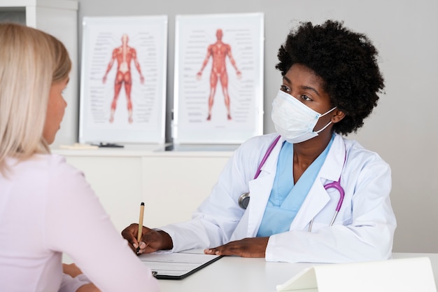 Foto gratuita medico di vista laterale che indossa una maschera per il viso