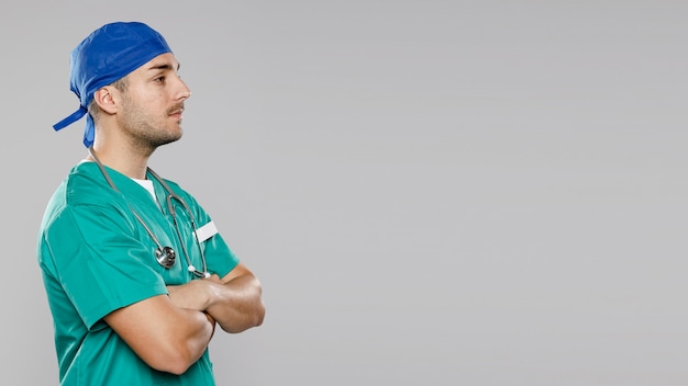 Free photo side view of doctor with crossed arms and copy space