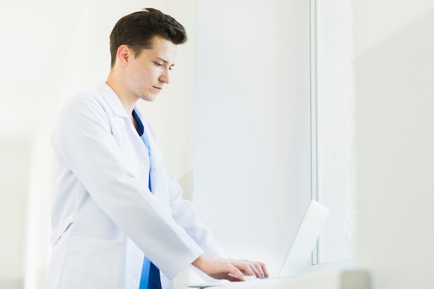 Side view of doctor with laptop