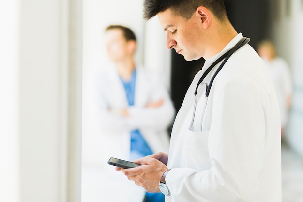 Side view of doctor with smartphone
